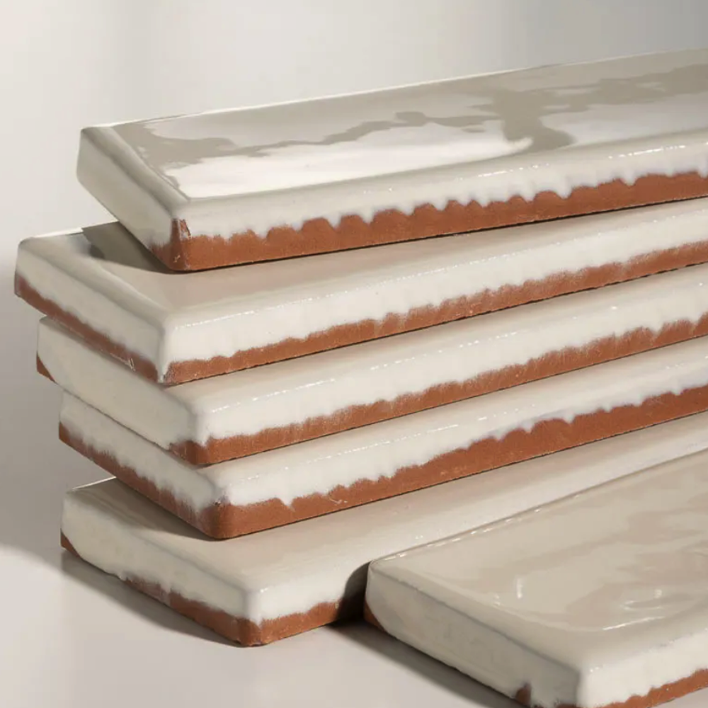 Stack of ceramic tiles with white glaze and brownish edge on a light background Avebury Ceramic