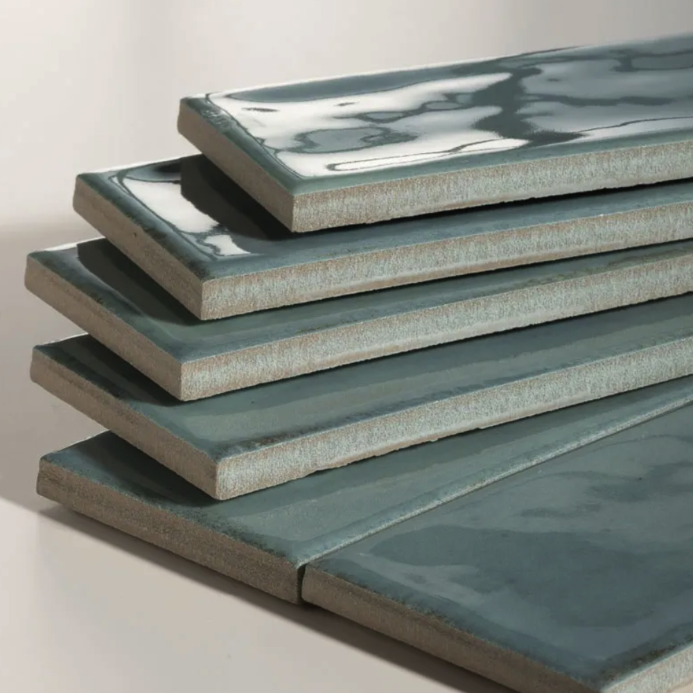 Stack of green ceramic tiles on a light gray background