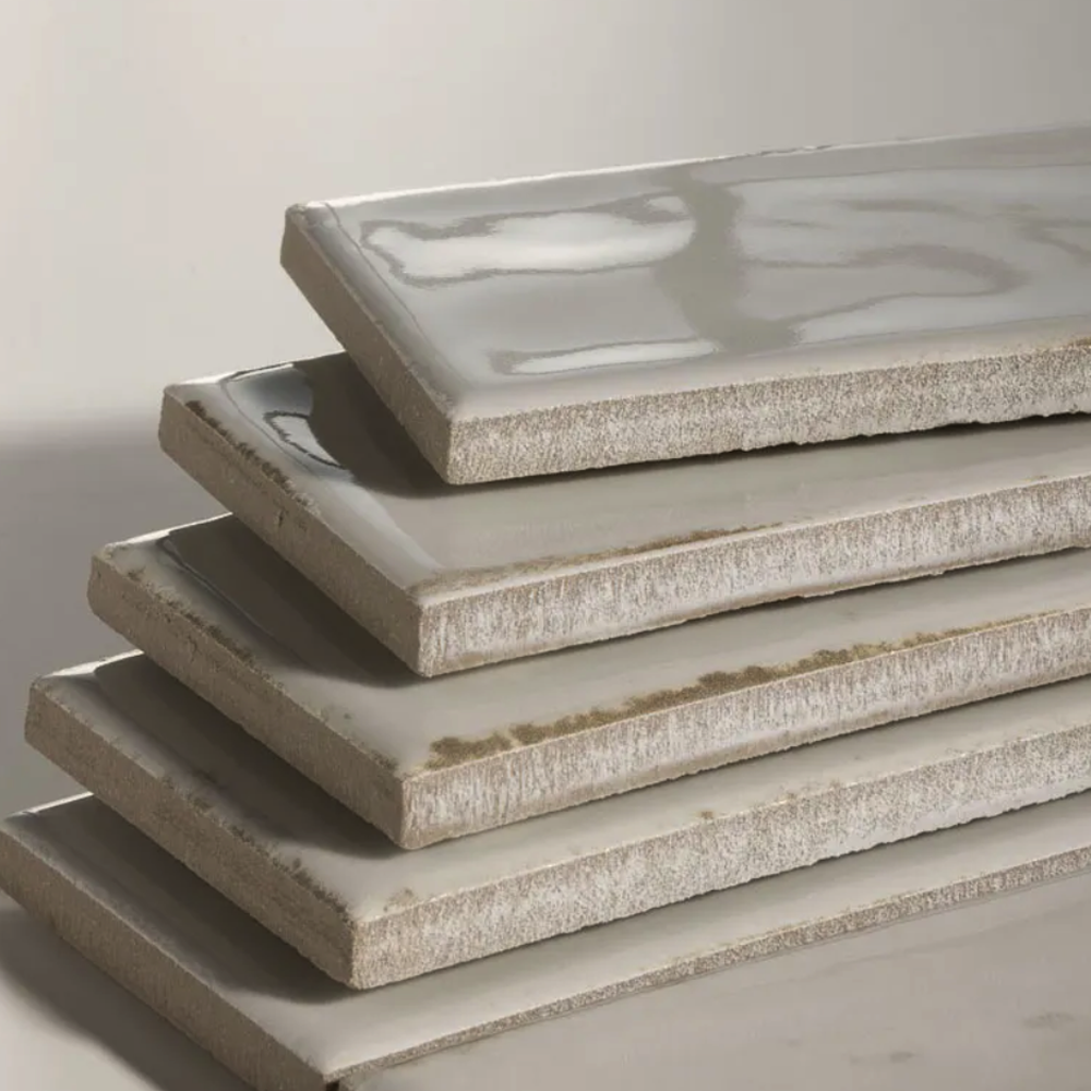 Stack of rectangular ceramic plates with textured surface on a light gray background