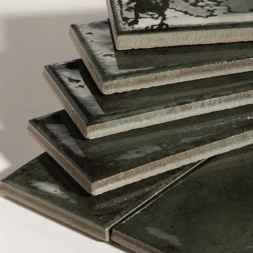 Stack of green ceramic tiles on a white surface