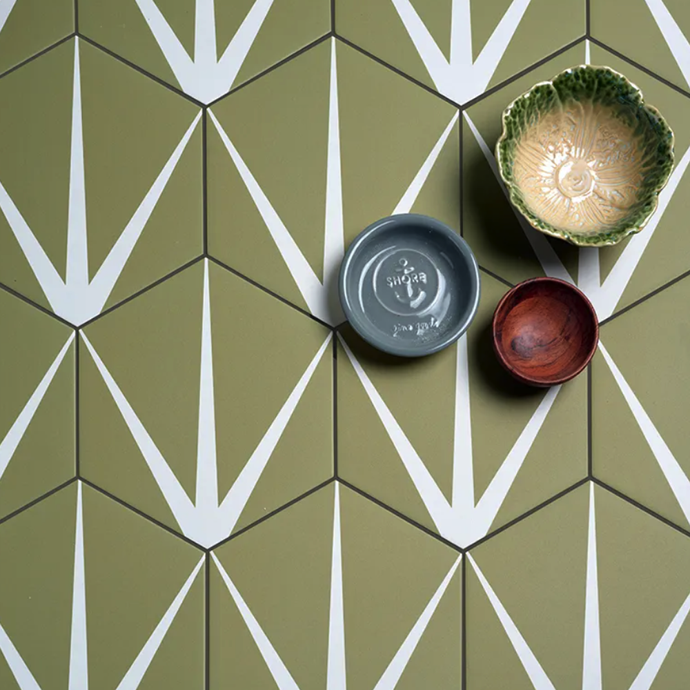 Three ceramic bowls on a green tile floor with geometric pattern