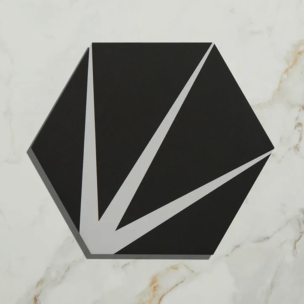 Black geometric tile with white lines on a marble surface