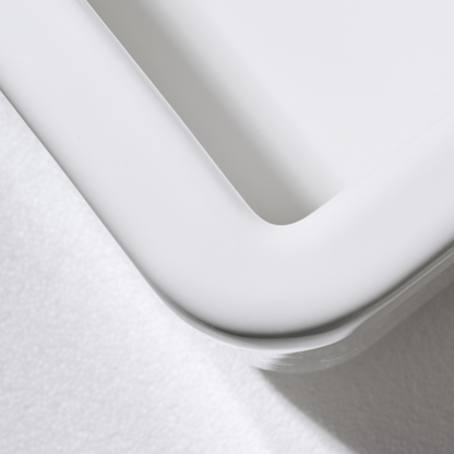 Close-up of a white toilet seat on a light gray background