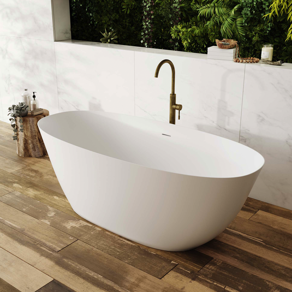 White freestanding bathtub with a bronze faucet in a modern bathroom setting.