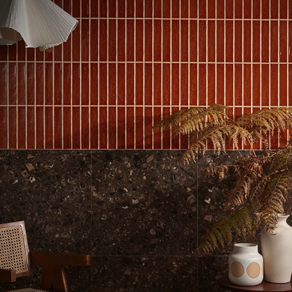Room interior with red tiled wall, dark stone floor, and decorative plants.