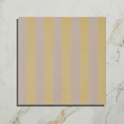Striped fabric swatch with yellow and beige stripes on a marble background