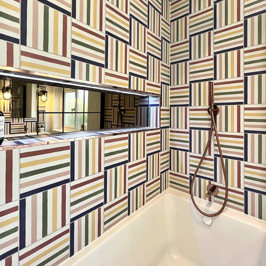 Bathroom with geometric patterned tiles and a shower head.