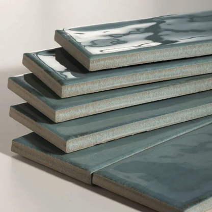 Stack of green ceramic tiles on a light gray background