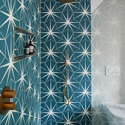 Bathroom with blue and white geometric tile pattern and gold fixtures.