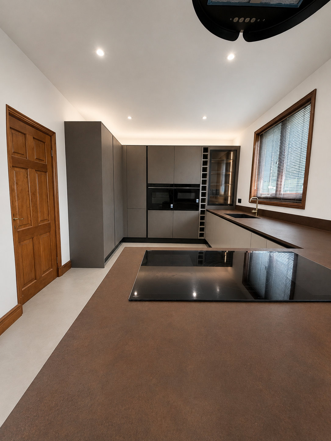 Bespoke kitchen with oxidised Liquid Metal Iron peninsula and Microstone Poured Floor in Chalk White, Trentham