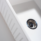 Close-up of a white kitchen sink with a drain