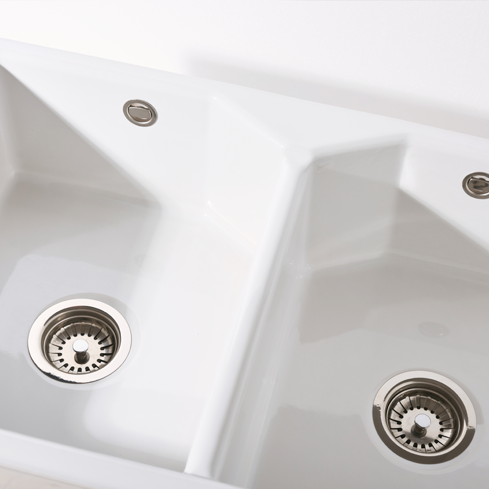 Close-up of a white kitchen sink with two drain holes.