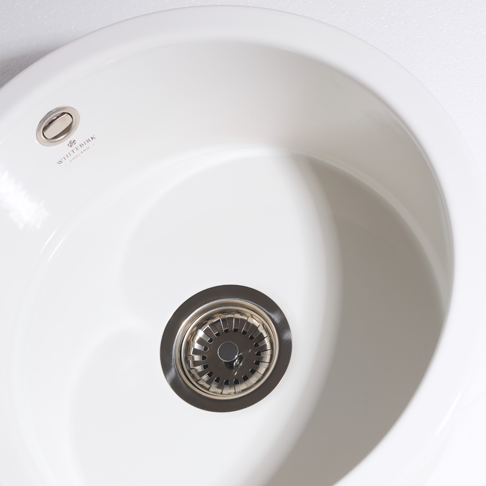White kitchen sink with a visible brand logo on a white background