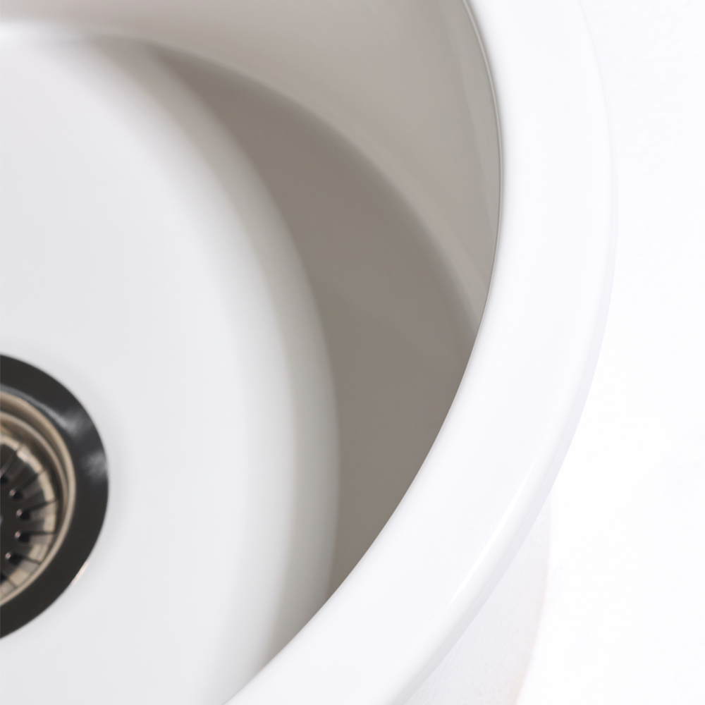 Close-up of a white kitchen sink with a drain.